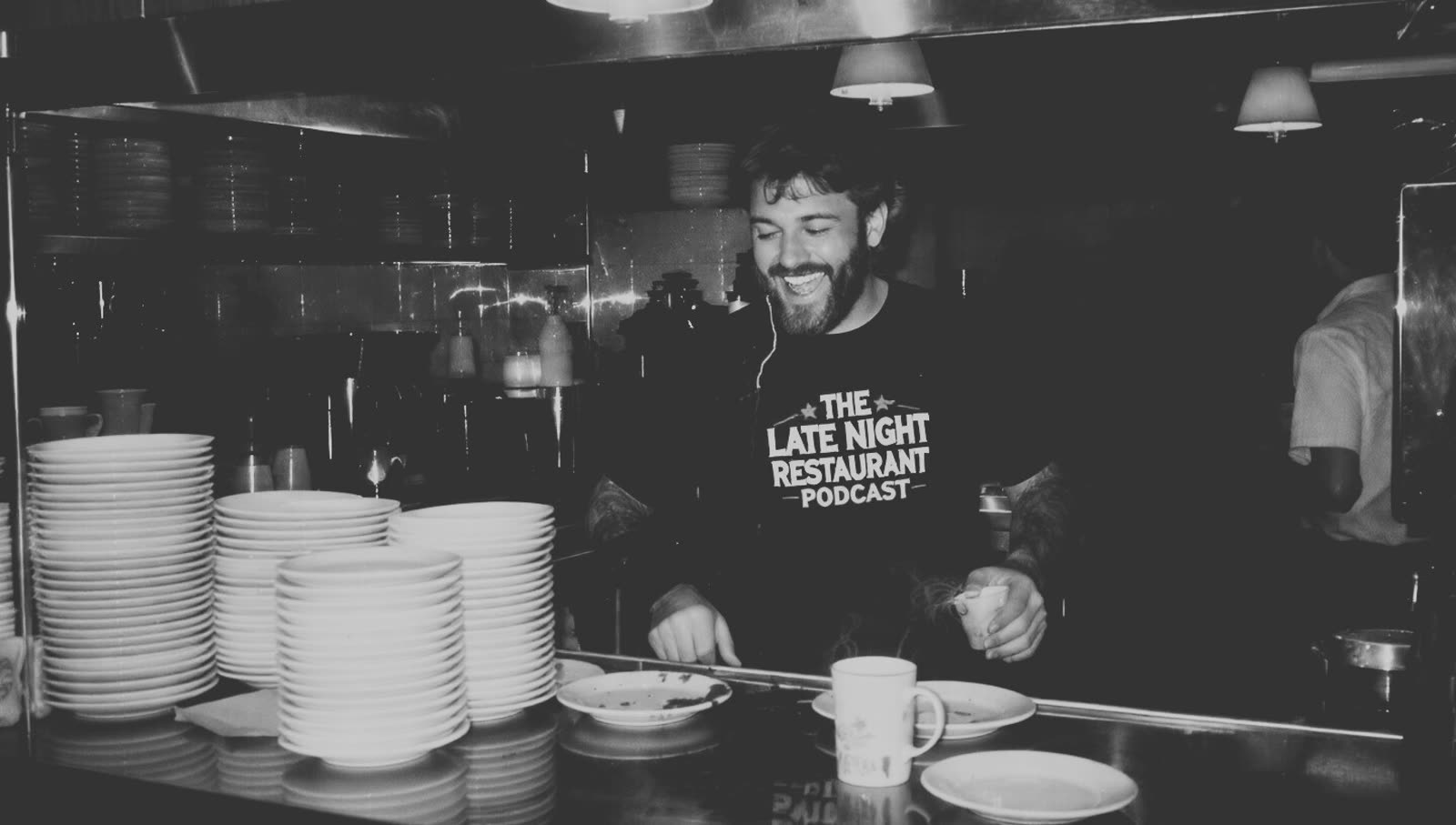 Guest in a Late Night Restaurant Podcast tee laughing on a restaurant pass